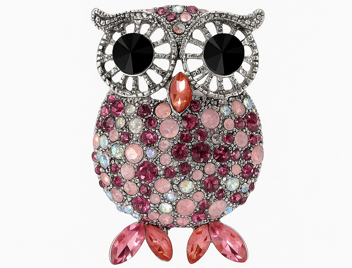 Owl brooch with silver-tone frame, large black eyes, and faceted stones in pink and iridescent tones, with pink leaf-like stones for feet. Cutout on white.  Landscape crop for secondary use.