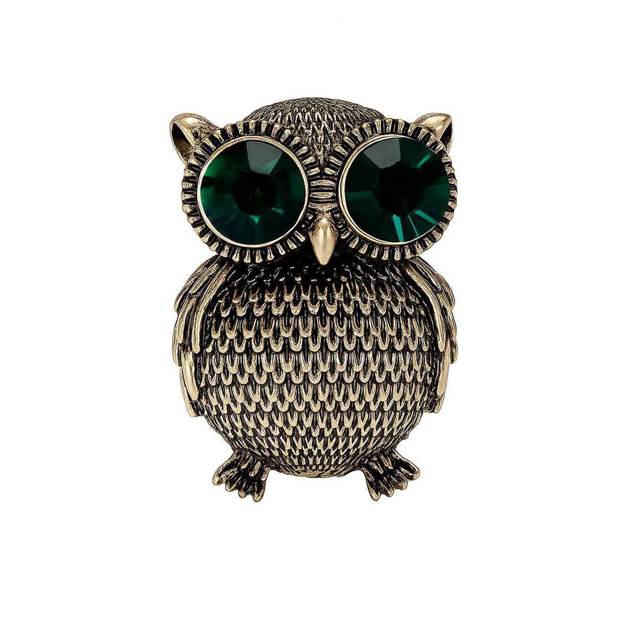 Owl brooch with textured gold-tone metal finish and large green faceted stone eyes, cutout on white background.