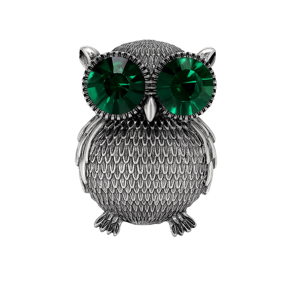 Owl brooch with textured silver-tone metal finish and oversized green faceted stone eyes, cutout on white background.