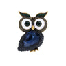 Owl brooch with dark blue faceted stone body, white eyes with dark green centers, and green accent stones on ears, cutout on white background.