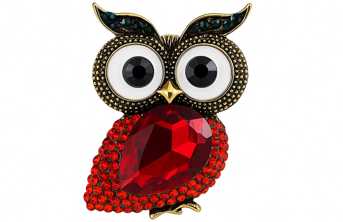 Owl brooch with red faceted stone body, white eyes with black centers, and green accent stones on ears, cutout on white background. Landscape crop for secondary use.