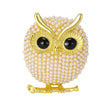 Owl brooch with gold-tone finish, small faux pearl beads, black eyes, and branch element, cutout on white background.