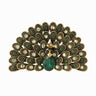 Peacock brooch with green and iridescent stones, gold-tone metal, and green teardrop center stone, cutout on white.
