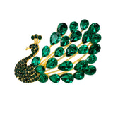 Peacock brooch with gold-tone metal setting, green teardrop stones, and clustered green round stones on body, cutout on white.