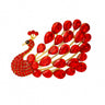 Peacock brooch with gold-tone metal finish, vivid red teardrop stones, and clustered red round stones, cutout on white.
