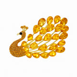 Peacock brooch with gold-tone metal setting, bright yellow teardrop stones, and matching round yellow stones, cutout on white.