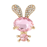 Bunny brooch with pink faceted stones, gold-tone limbs and bow, and crystal-studded ears, cutout on white background.