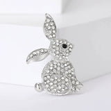 Bunny brooch with silver-tone metal, clear faceted stones, and black eye detail, upright pose on white background.