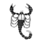 Scorpion brooch with silver-tone finish, black faceted stones, and segmented tail, isolated on white background.