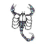 Scorpion brooch with silver-tone body, purple-blue iridescent stones, and raised claws, isolated on white background.