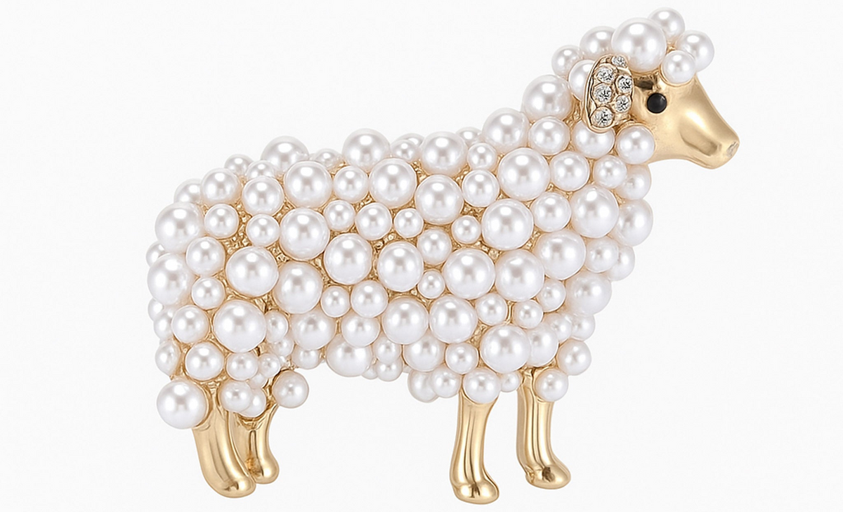 Sheep brooch with gold-tone metal, white round beads, and small clear stones on ear, cutout on white background. Landscape crop for secondary use.