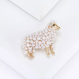 Sheep brooch with gold-tone finish, clustered white round beads, and clear ear stones, angled view on white surface.