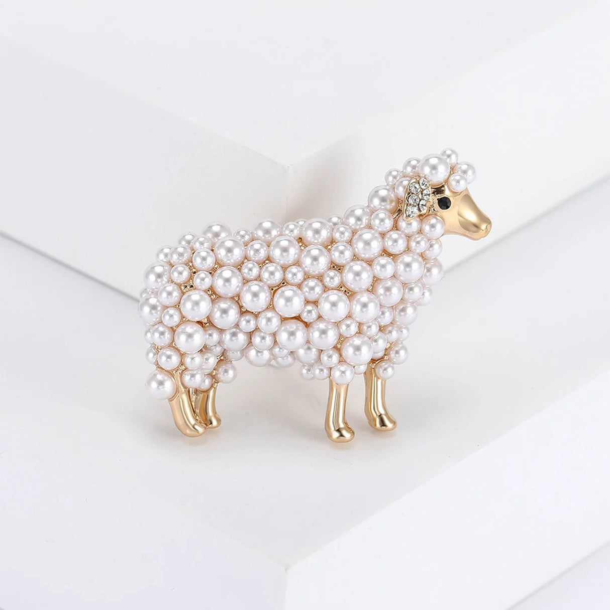 Sheep brooch with gold-tone metal, white round beads in varied sizes, upright pose on white studio background.