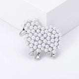 Sheep brooch with silver-tone metal finish and white imitation pearls forming a textured body, displayed on white block in studio.