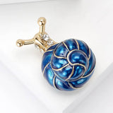 Snail brooch with blue-toned swirl shell, gold-tone metal and clear faceted stones, top-left angled view.