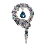 Snake brooch with silver-tone base, multicolor faceted stones in purple, blue, and beige, and dark blue teardrop pendant, cutout on white.
