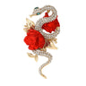 Snake brooch in gold-tone metal with clear pave-set stones, green eyes, and red rose detailing. Cutout on white background.