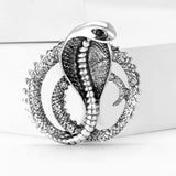Silver-tone cobra brooch with clear accent stones and textured coiled body, upright on white studio background.