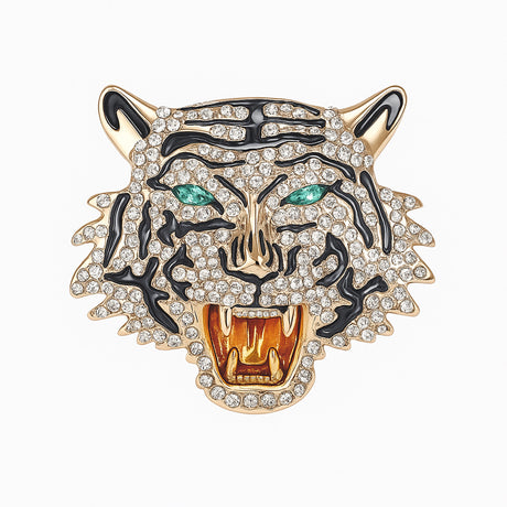 Roaring tiger head brooch with gold-tone base, clear faceted stones, black enamel stripes, and green-tone eyes, cutout on white.