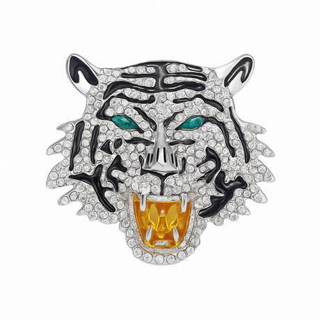 Tiger head brooch with silver-tone base, clear faceted stones, black enamel details, and green-tone eyes, cutout on white.