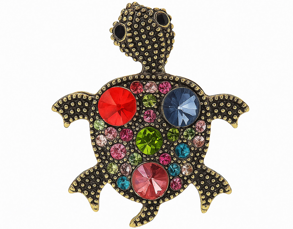 Turtle brooch with antique-inspired gold-tone dotted metal surface and multicolor round faceted stones in pink, red, blue, and green. Cutout on white. Landscape crop for secondary use.
