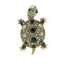 Tortoise brooch with gold-tone metal finish, dark green center stones, and iridescent green accents, cutout on white.
