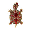Tortoise brooch with gold-tone metal finish, red faceted center stones, and round red accents, cutout on white.