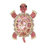 Tortoise brooch with large pink faceted center stone, small round accents, and gold-tone edging. Cutout on white background.